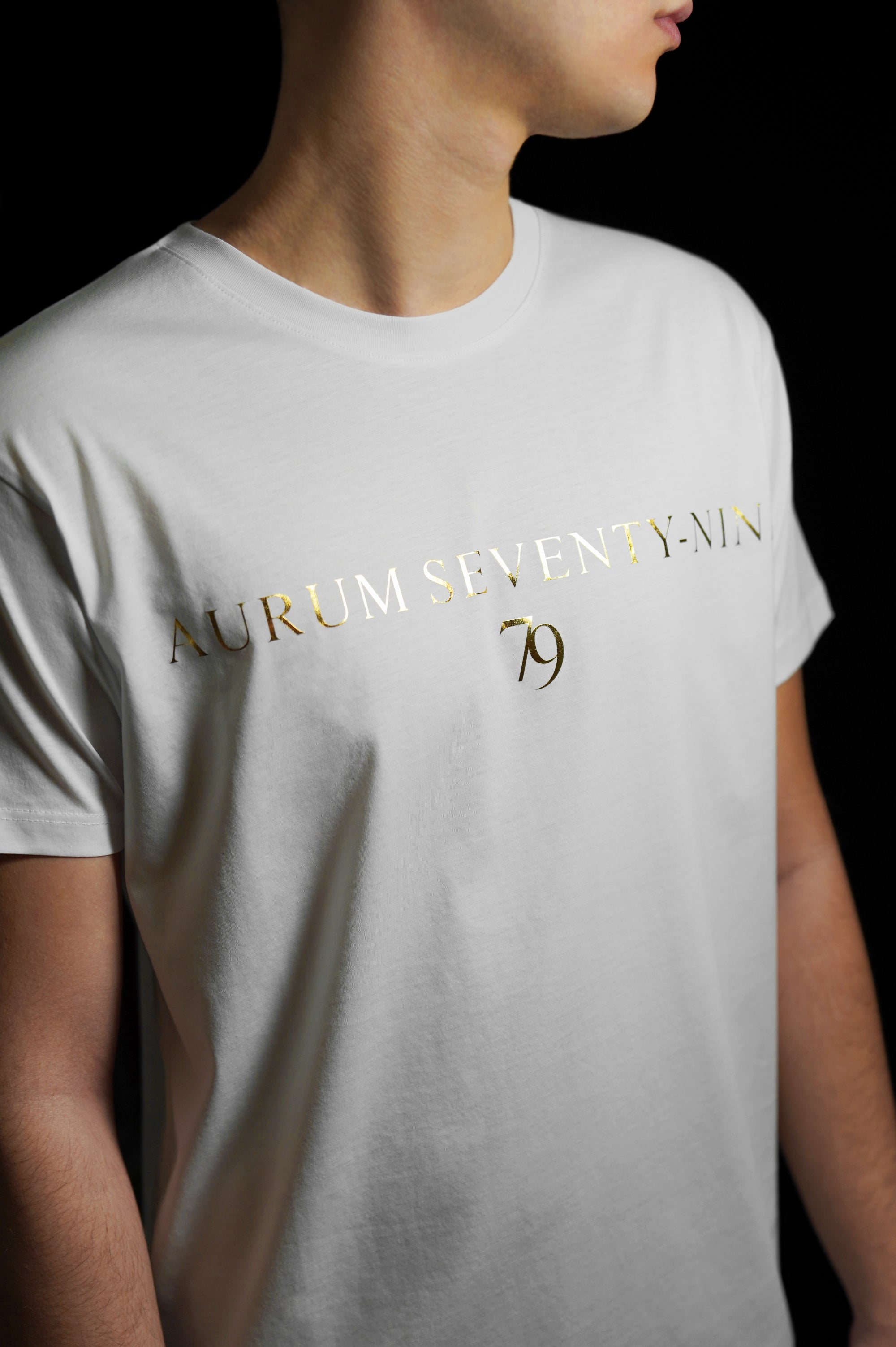 Aurum Seventy-nine: Vista laterale di un modello che indossa la T-shirt Round Neck Aurum 79 Classic White, con una vestibilità elegante e confortevole.