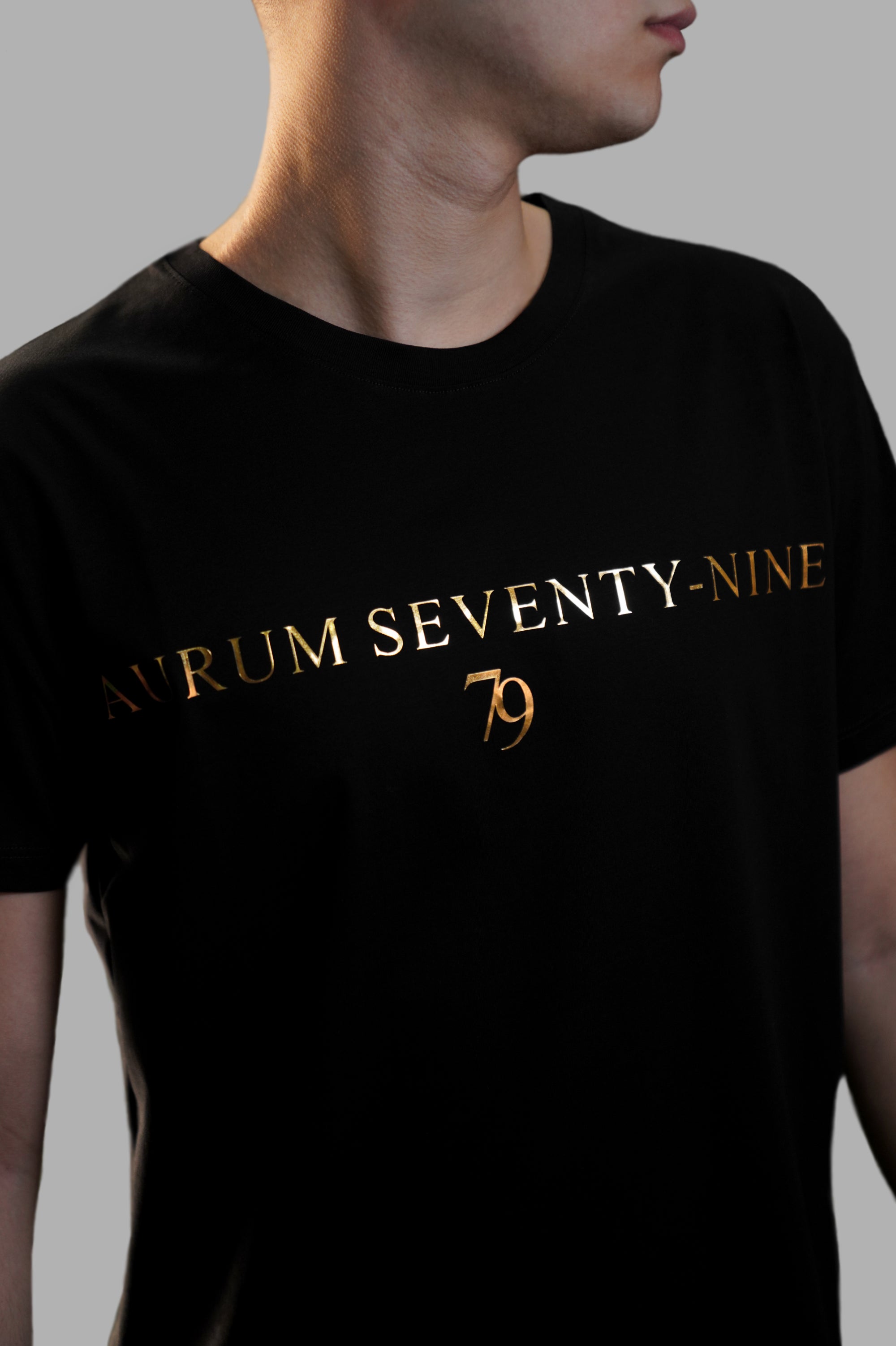 Aurum Seventy-nine: Vista laterale di un modello che indossa la T-shirt Round Neck Aurum 79 Classic Black, con una vestibilità elegante e confortevole.